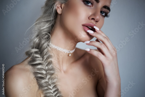 Perfect beauty girl portrait with totally blonde hair pigtail and perfect makeup, work with camera and posing