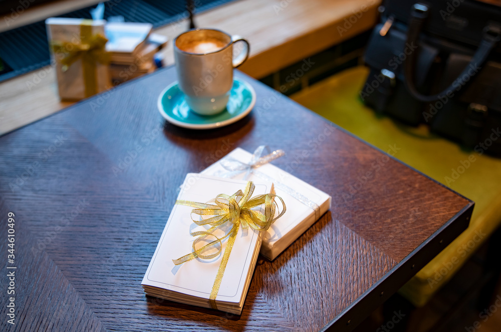 Cup of coffee with notebook gifts on wooden table Cup of coffee with notebook gifts on wooden table