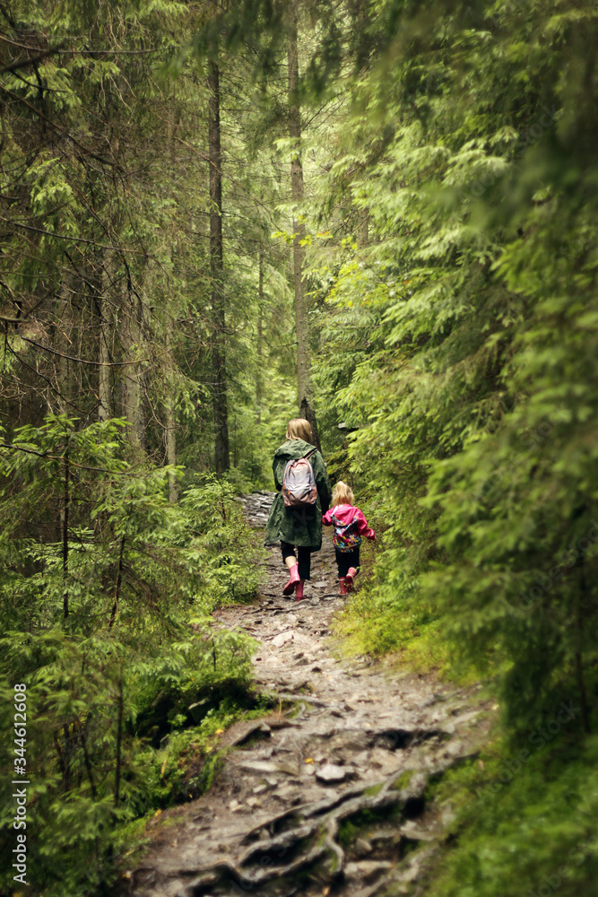 Mom and daughter are walking in the forest