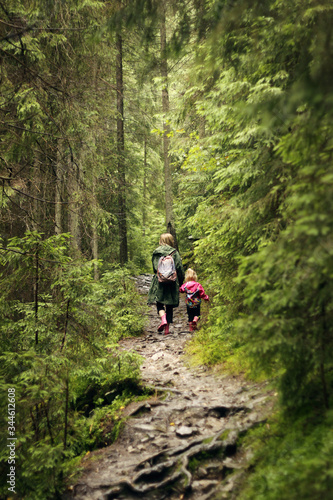 Mom and daughter are walking in the forest