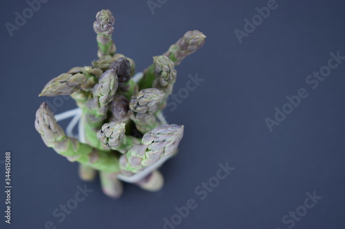 Bundle of young green asparagus on black texture backgroun. Healthy eating. Close up. Overhead shot