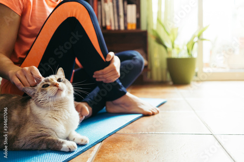 Young girl with domestic cat after a workout . Fitness lifestyle concept at home.