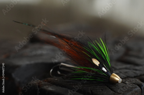 Obraz na płótnie Traditionally dressed salmon fly shot against a wood background w salonie