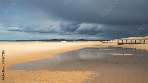 Fotografie, Obraz beach and sea bathed in sunshine before a storm