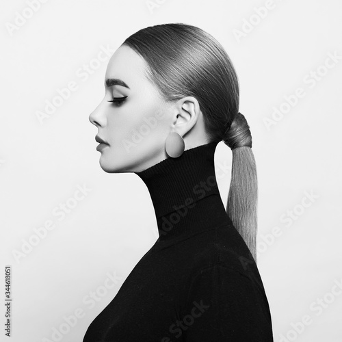 Art portrait of a beautiful, elegant woman in a black turtleneck and gold jewelry