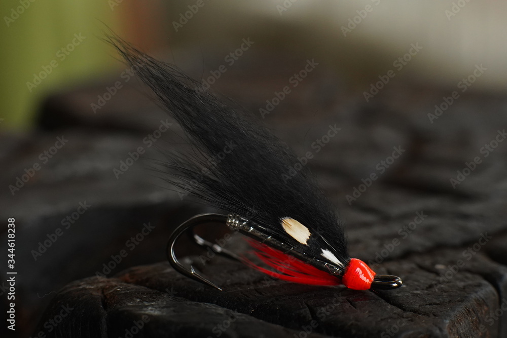 Traditionally dressed salmon fly shot against a wood background