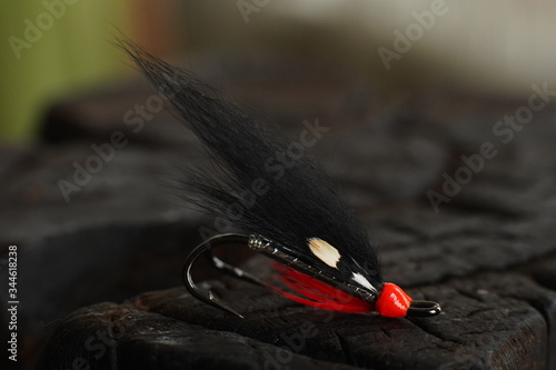 Obraz na płótnie Traditionally dressed salmon fly shot against a wood background w salonie