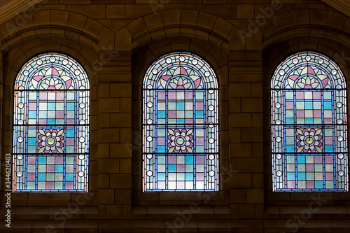 Canvas Print Trio of stained glass windows. Three ornate purple pink windows.