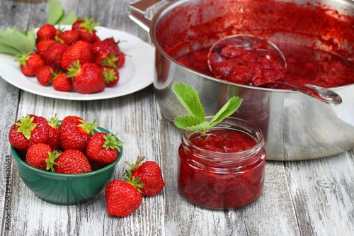 Jar of tasty homemade strawberry preserve. Strawberries harvest needed to preserve. Homemade organic red strawberry jam.