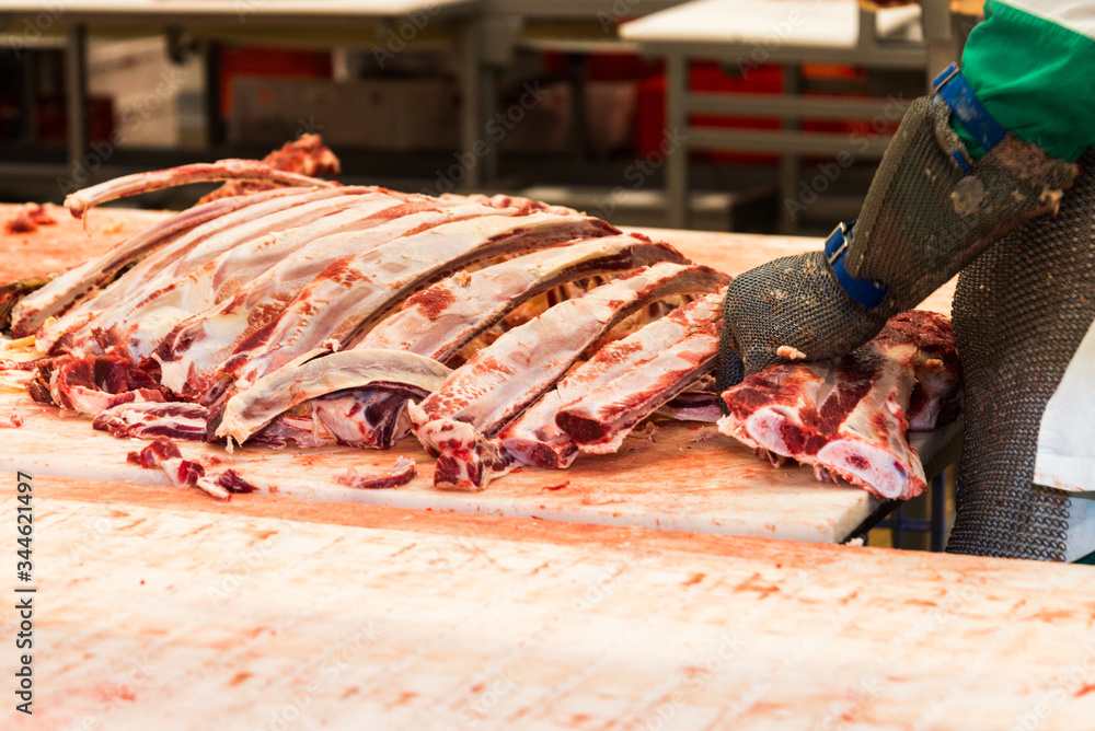 A man cuts a carcass of a cow at a meat factory