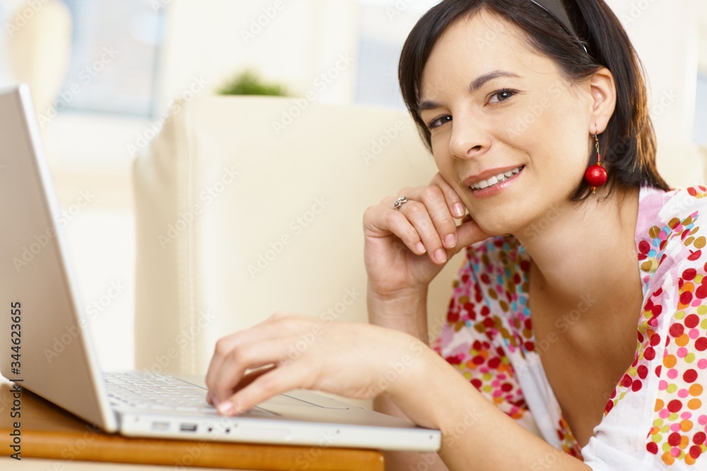 Young caucasian woman using computer at home, copy space. Young caucasian woman using computer at home, copy space.