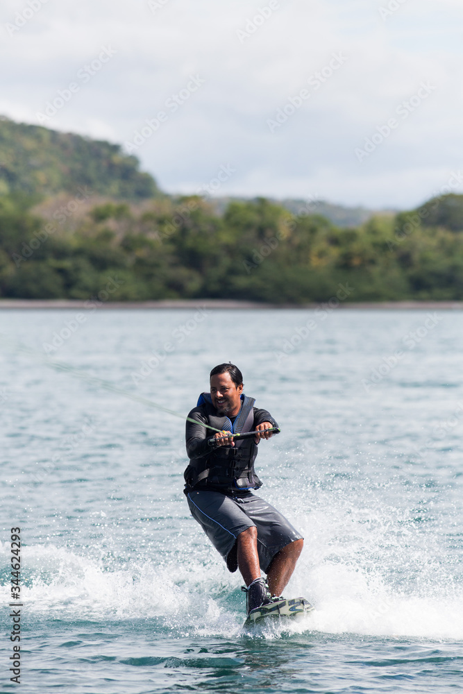 Latino man wake boarding in Costa Rica.
Latino man wake boarding in Costa Rica.
