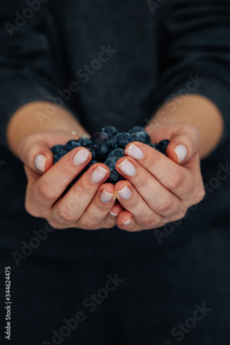 Woman with handful of freshly picked organic blueberries