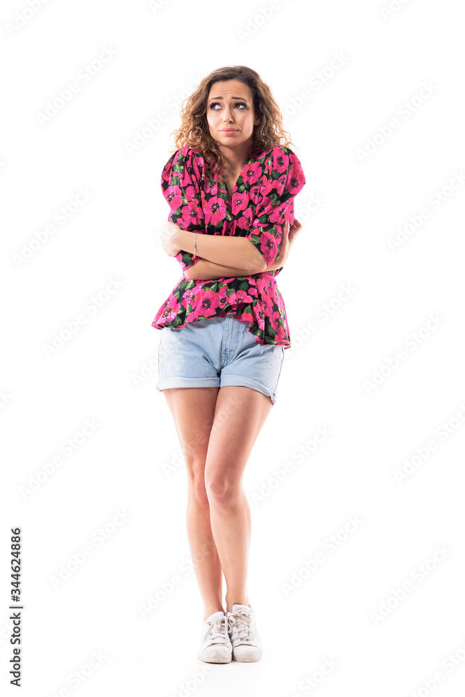 Sad young woman in summer clothes looking away hugging herself shaking of flu or cold weather. Full body length isolated on white background. Sad young woman in summer clothes looking away hugging herself shaking of flu or cold weather. Full body length isolated on white background.