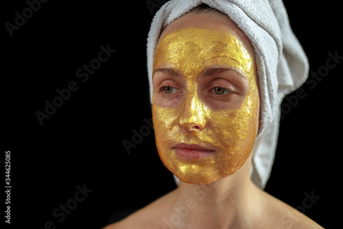 Woman face with golden hydrogel mask