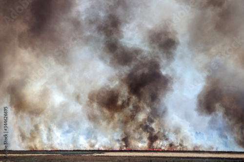 Strong prairie fire with large clouds of choking smoke erupted in southern steppe during the summer drought. The line of fire is coming to town houses. Ecological catastrophy