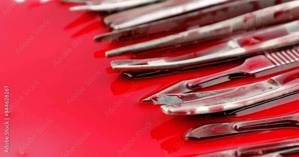 Dolly out close up of surgical instrument tools with blood, scalpel forceps tweezers, scissors for surgeon in surgery Dolly out close up of surgical instrument tools with blood, scalpel forceps tweezers, scissors for surgeon in surgery
