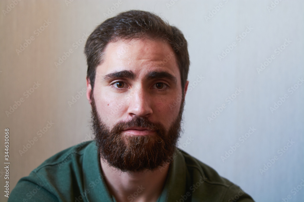 Portrait of young guy with dark beard with various emotions on his face in green shirt. Portrait of young guy with dark beard with various emotions on his face in green shirt.