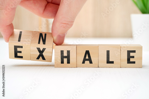 Abstract selection of inhale exhale phrases on wooden blocks.