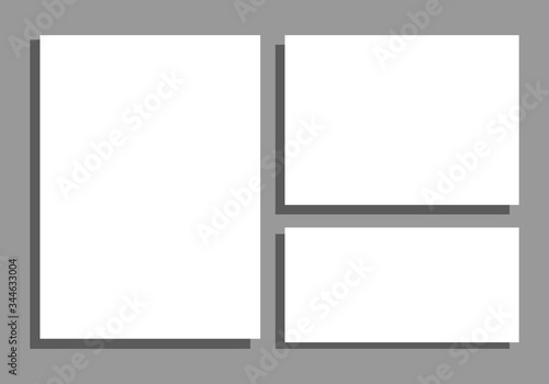 Hojas de papel en blanco sobre fondo gris.