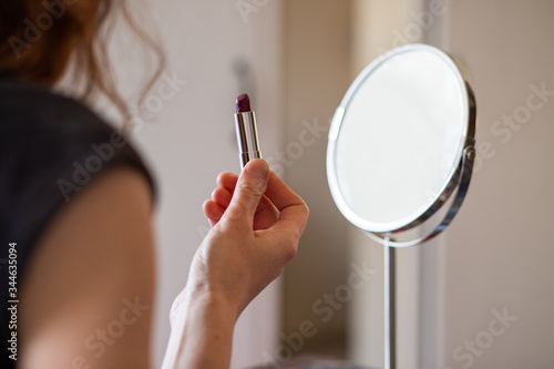 woman applying makeup focus on lipstick