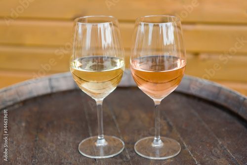 Wine glasses with white and rose wines on the cork table