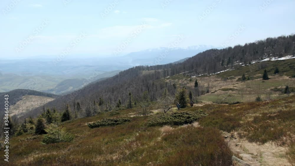 Two people climb to the top of the mountain in the spring. Two people climb to the top of the mountain in the spring.