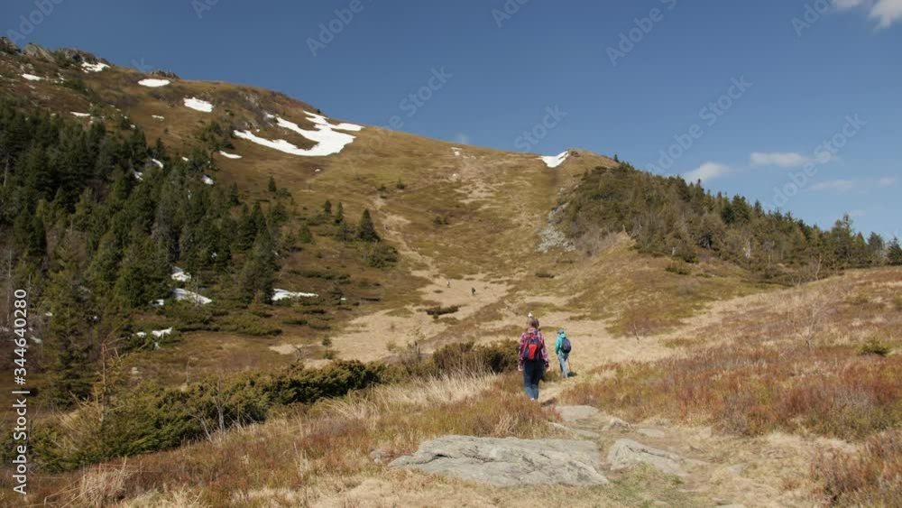A group of people climb to the top of a mountain through the picturesque mountains in the spring. A group of people climb to the top of a mountain through the picturesque mountains in the spring.