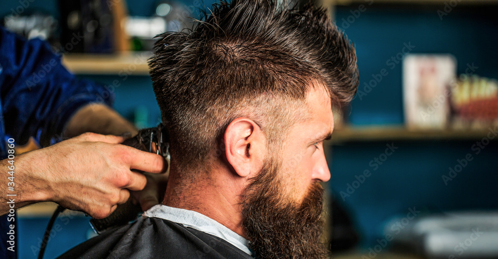Hands of barber with hair clipper, close up. Haircut concept. Man visiting hairstylist in barbershop. Barber works with hair clipper. Hipster client getting haircut Hands of barber with hair clipper, close up. Haircut concept. Man visiting hairstylist in barbershop. Barber works with hair clipper. Hipster client getting haircut