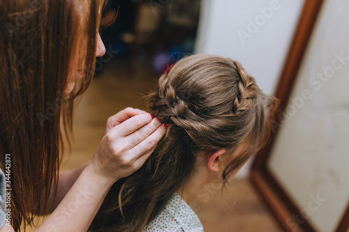 Girl professional hairdresser braids the pigtail to the bride and makes a hairstyle close-up. Photography, concept.