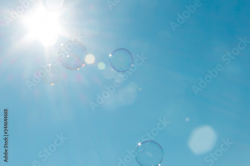 Soap bubbles floating in the air bathed by intense sunlight