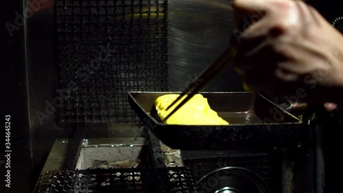 Slow Motion of tamagoyaki omelettes in metal pans at a street food market in downtown Tokyo. Popular Japanese street food in the izakaya restaurant.-Dan photo