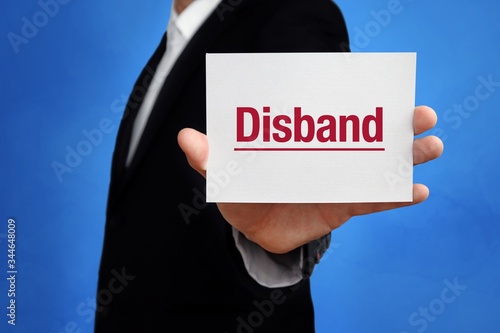 Disband. Lawyer in a suit holds card at the camera. The term Disband is in the sign. Concept for law, justice, judgement