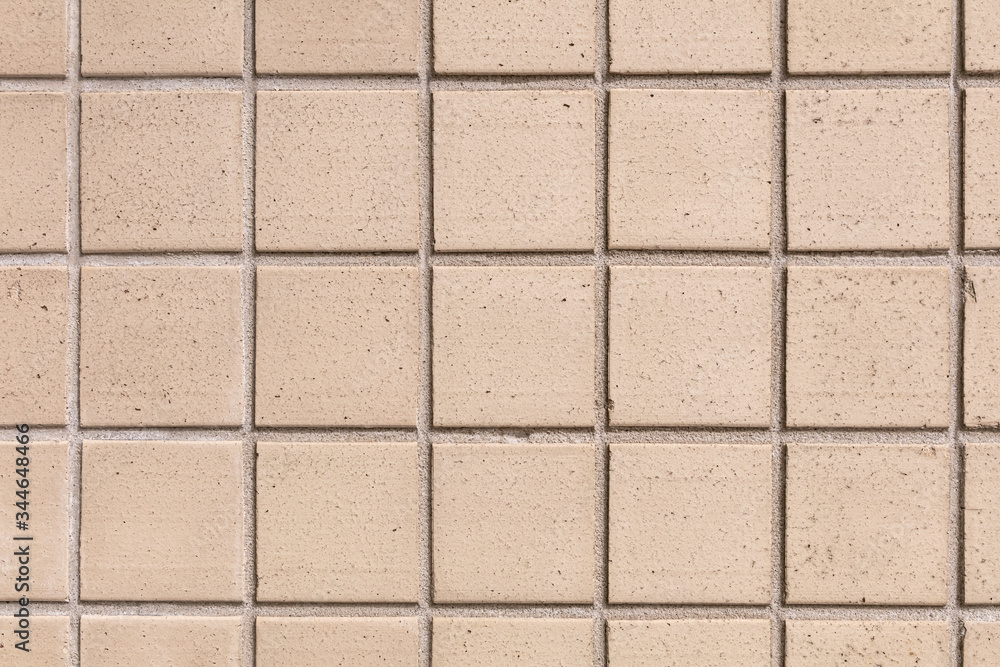 Naklejka premium Beige square tile. Close-up wall