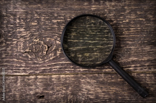 magnifying glass on old wooden background