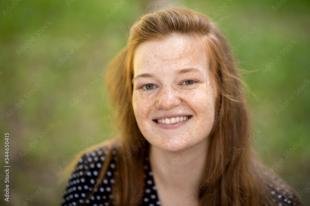Portrait of a beautiful  woman without makeup on the summer green background. Natural Beauty Concept