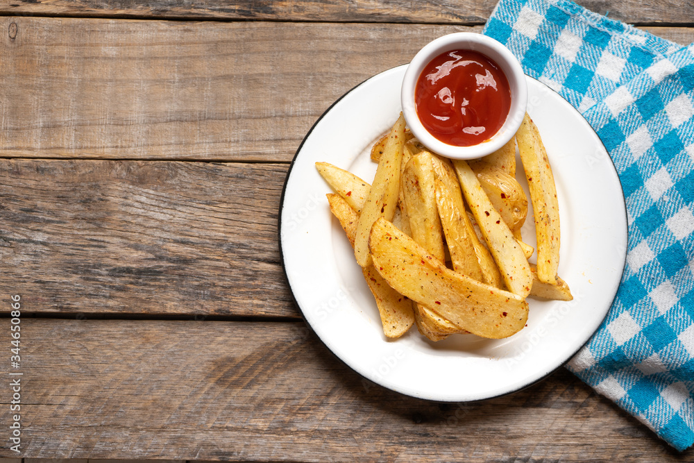 French fries with ketchup sauce on wooden background French fries with ketchup sauce on wooden background
