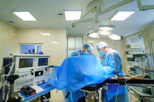 Surgeons working in operating room. Hospital background. Doctors at work. Circular background of an operation on a spinal cord, vertebra