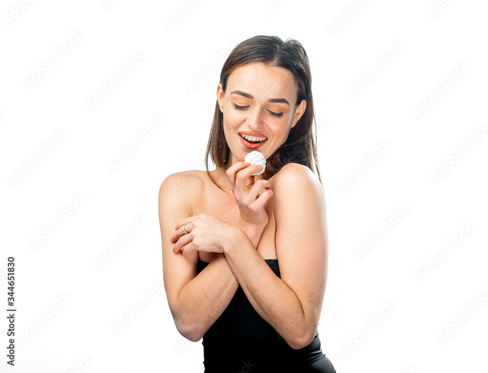 Portrait of charming beautiful woman in deep neckline dress. Girl with closed eyes holds one marshmallow near mouth. White background. Pretty female with closed eyes in black lingerie. Portrait of charming beautiful woman in deep neckline dress. Girl with closed eyes holds one marshmallow near mouth. White background. Pretty female with closed eyes in black lingerie.