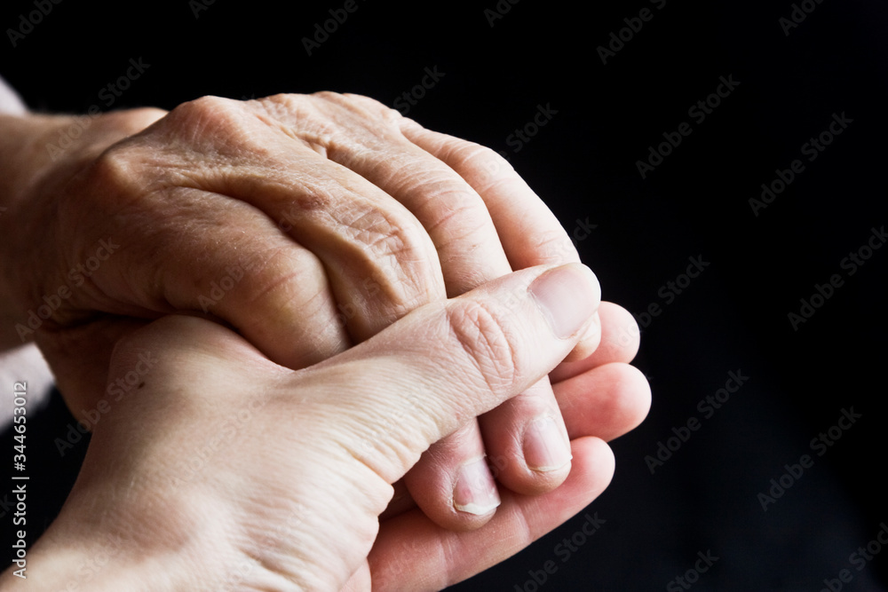 Grandmother's old wrinkled hand in a young hand close-up. Hands of an ...