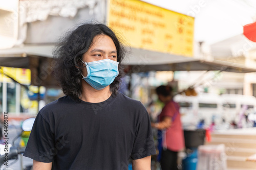 Asian man is wearing mask stand in the crow during covid19 or corona virus spread
