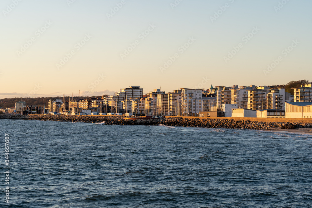 Helsingborg coastline as seen from pier at sunset on a windy spring day in Scania, Sweden.