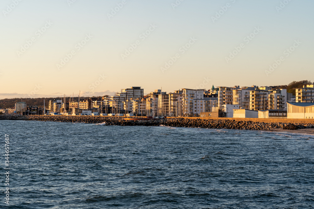 Fototapeta premium Helsingborg coastline as seen from pier at sunset on a windy spring day in Scania, Sweden.