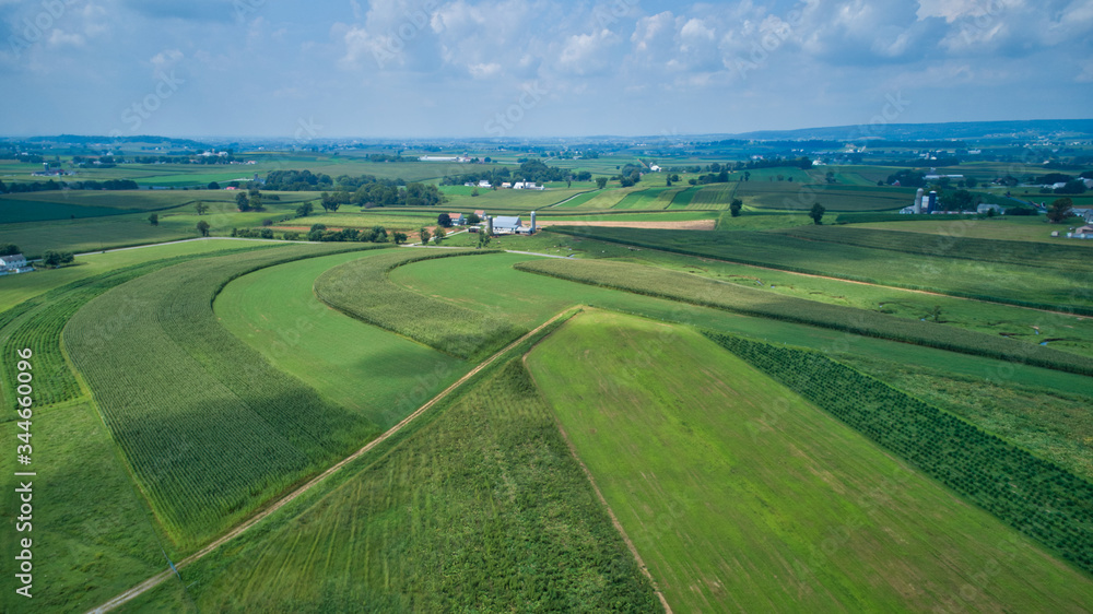 Aerial view of green farmlands and rolling crops growing on a beautiful sky on a sunny countryside Aerial view of green farmlands and rolling crops growing on a beautiful sky on a sunny countryside