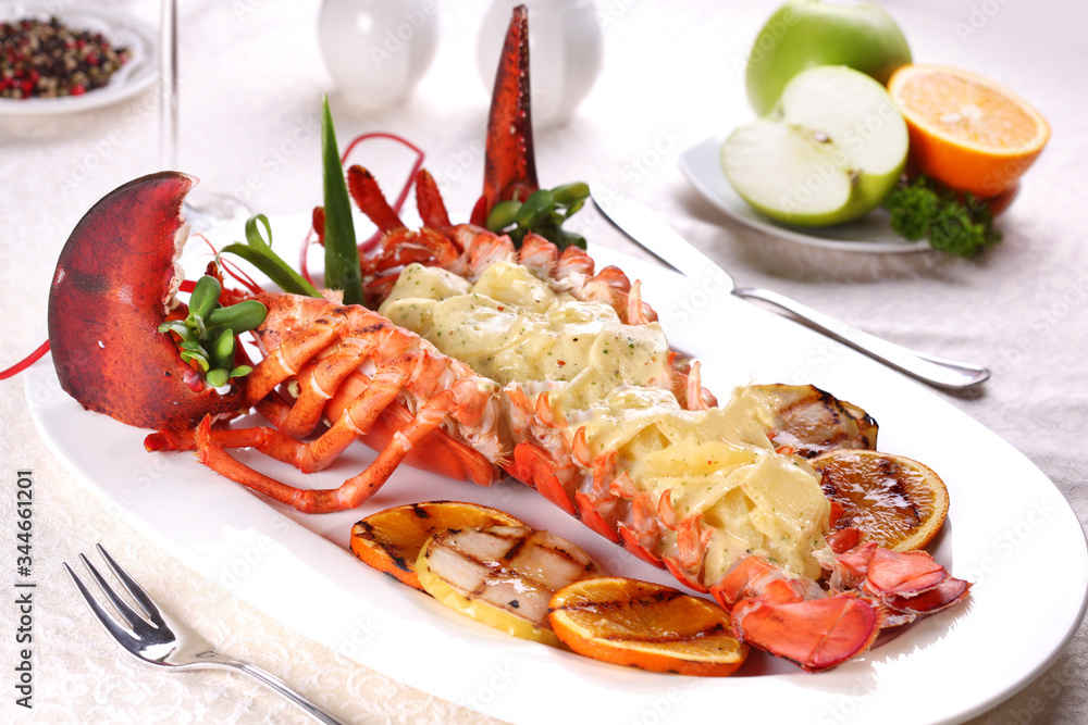 Baked lobster with applesauce and grilled bbq fruit on a white plate in a restaurant. Baked lobster with applesauce and grilled bbq fruit on a white plate in a restaurant.