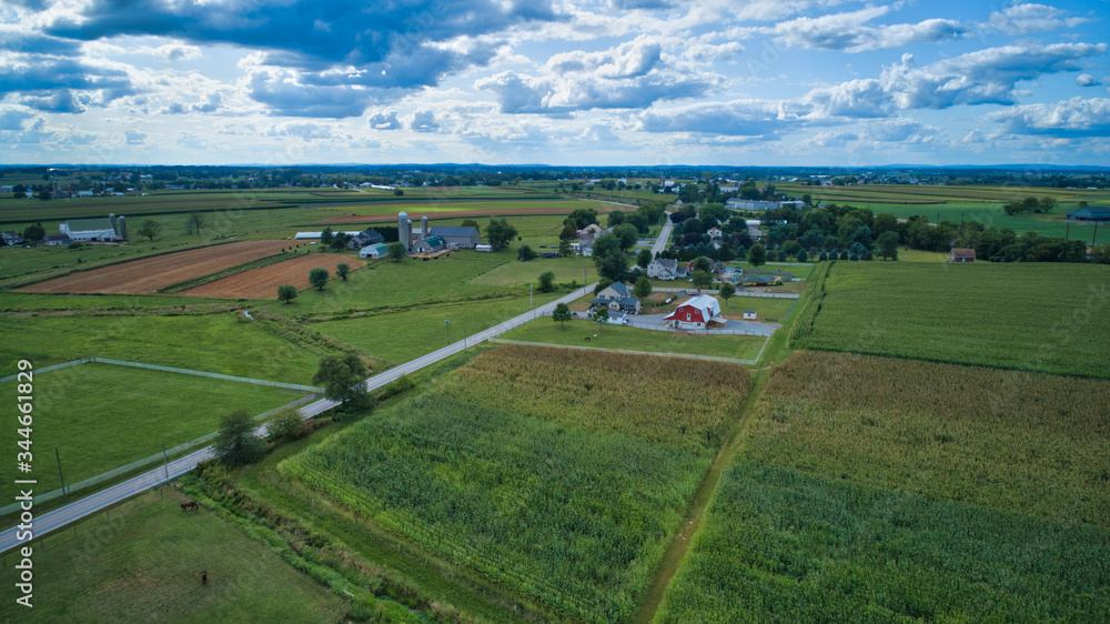 Aerial view of Amish countryside with barns and silos on a sunny summer day