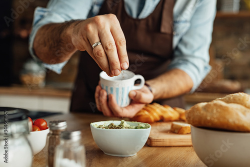 Close-up of man seasoning food while cooking in the kitchen. photo