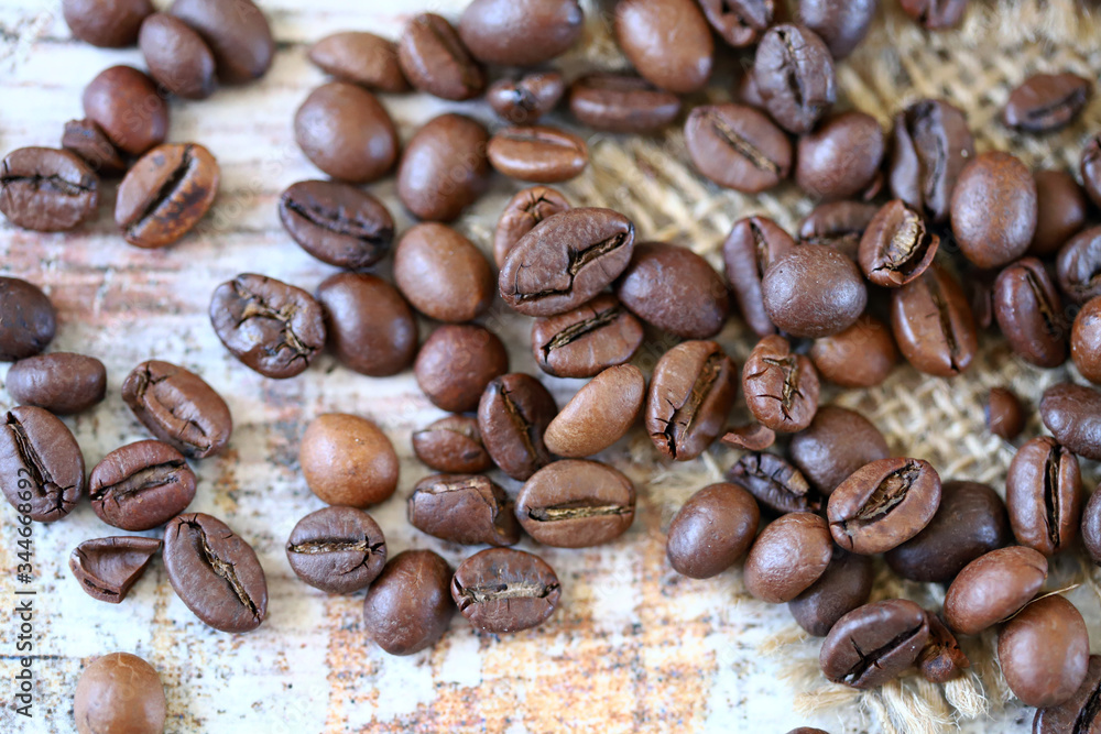 Selective focus. Macro. Coffee beans are scattered on a wooden surface. Selective focus. Macro. Coffee beans are scattered on a wooden surface.