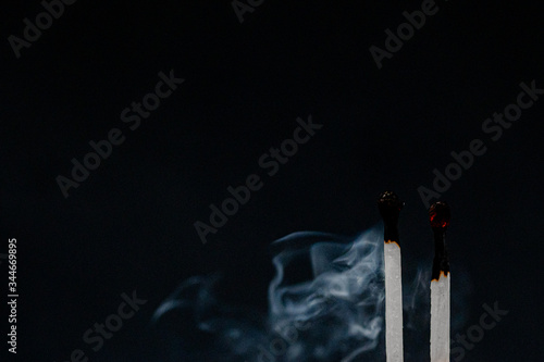 Smoke rising from extinguished matchsticks