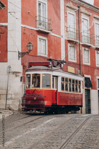 Lisbon, Portugal. Vintage red retro tram on street tramline in Alfama district of old town. Popular touristic attraction